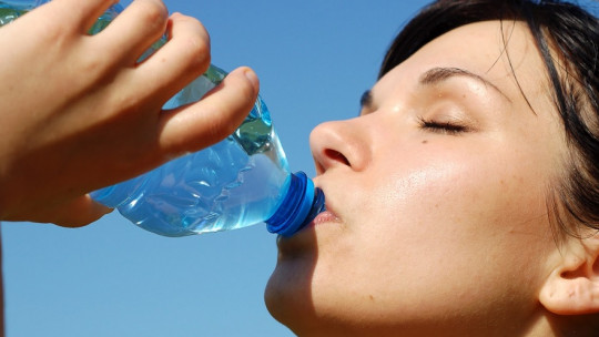 Mujer bebiendo agua.