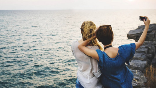 Mujeres tomándose una selfie en la costa.