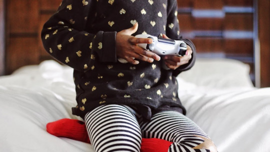 Niña pequeña jugando con una videoconsola.
