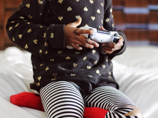 Niña pequeña jugando con una videoconsola.