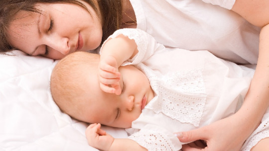 Madre durmiendo con su bebé.