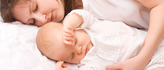 Madre durmiendo con su bebé.