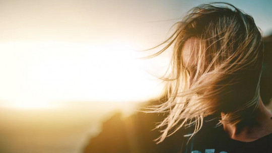 Mujer frente a una puesta de Sol.