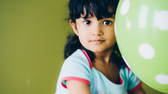 Niña jugando con un globo.