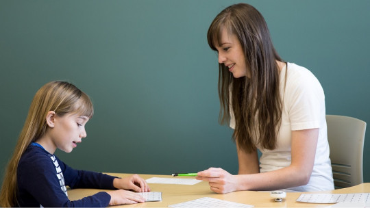 Educadora con niña con dislexia