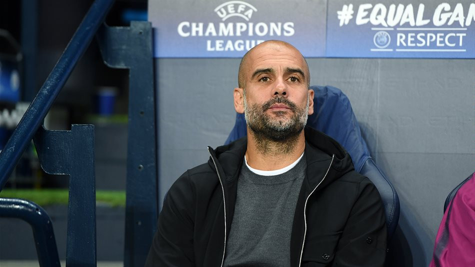Pep Guardiola sentado en el banquillo